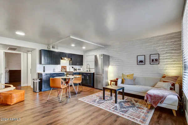 a living room with furniture a wooden floor and a dining table
