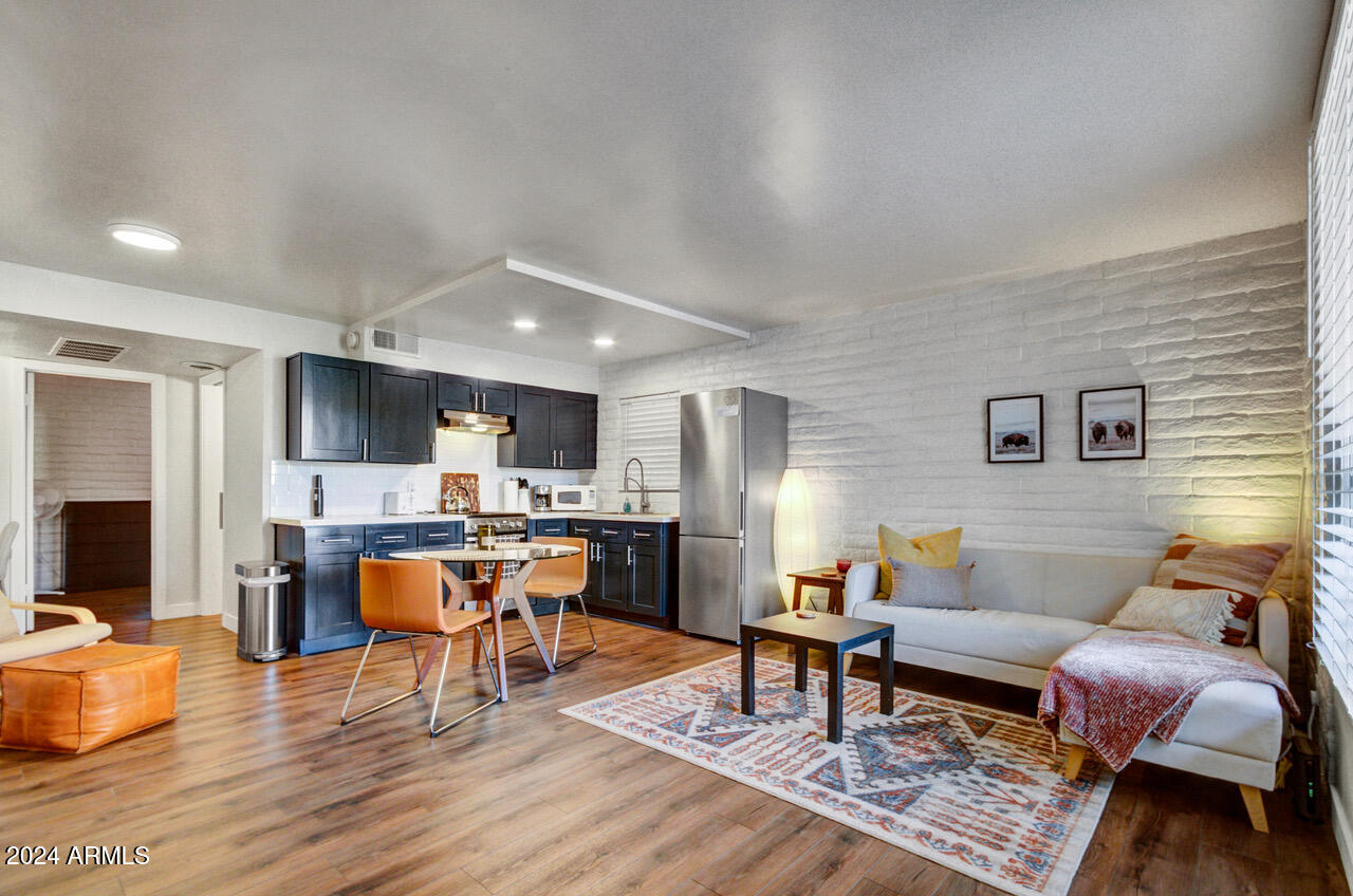 3737 East Turney Avenue, Unit 116 Phoenix, AZ 85018 - Photo 3 of 24 a living room with furniture a wooden floor and a dining table
