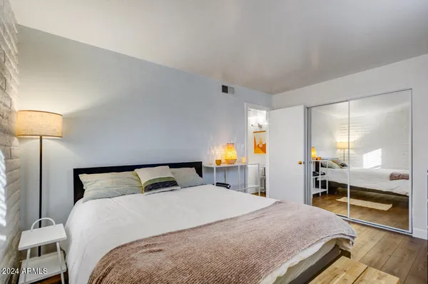 a bedroom with a bed and a large mirror