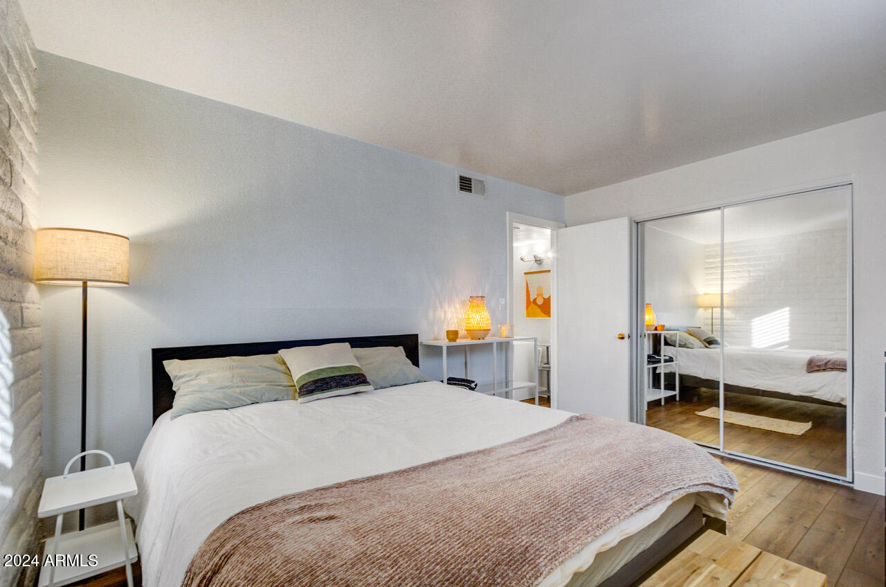 3737 East Turney Avenue, Unit 116 Phoenix, AZ 85018 - Photo 10 of 24 a bedroom with a bed and a large mirror