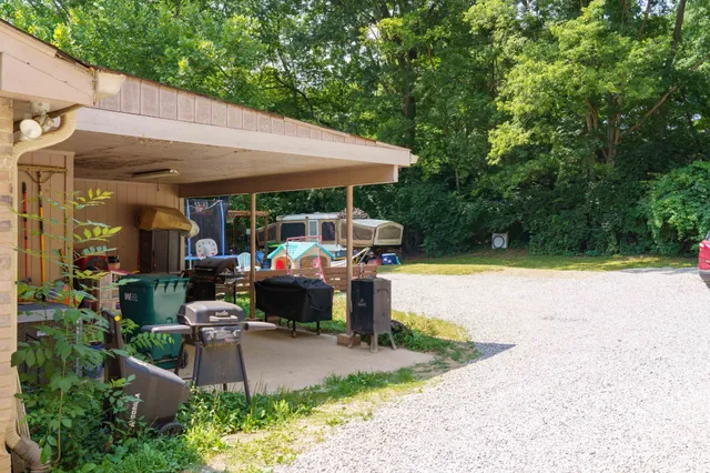 a front view of a house with garden and sitting area