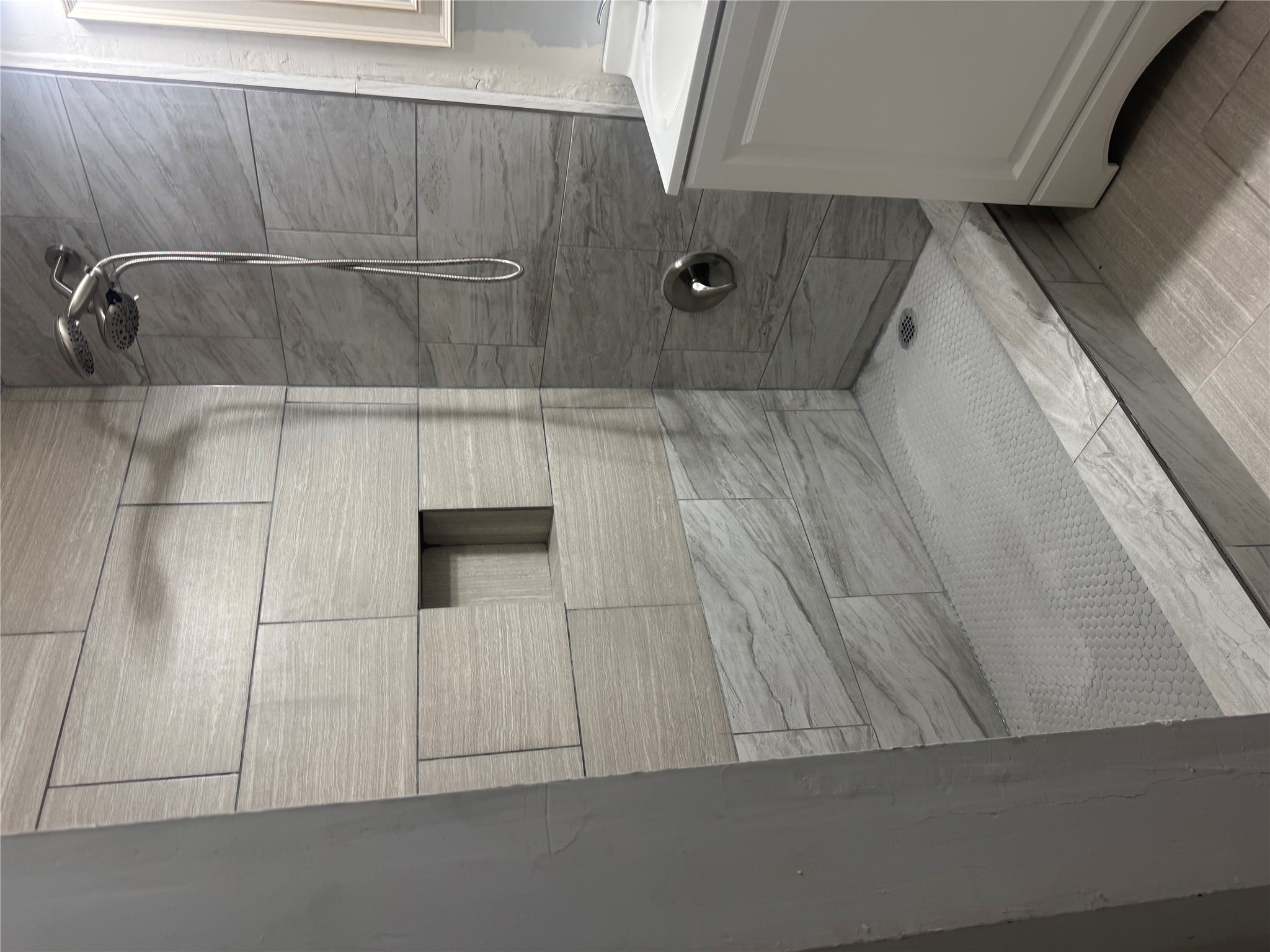 6304 Hudson Bend Road Austin, TX 78734 - Photo 6 of 10 A contemporary shower with sleek tiled walls and a functional built-in niche.
