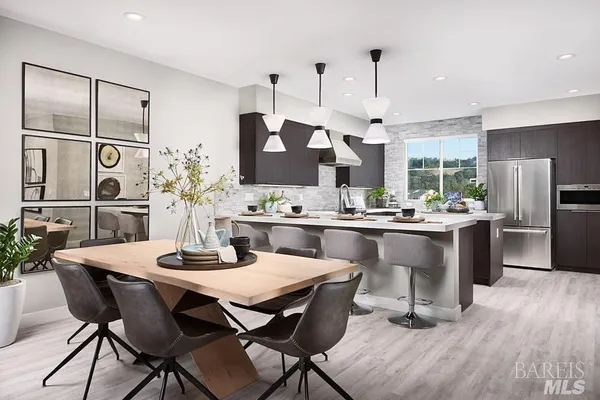 a kitchen with a table chairs refrigerator and cabinets