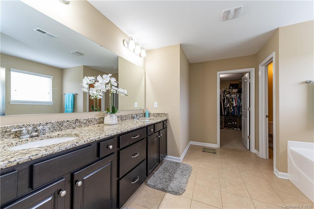 79362 Ridgehaven Road Lancaster, SC 29720 - Photo 23 of 37 a bathroom with a granite countertop sink a mirror and a bathtub