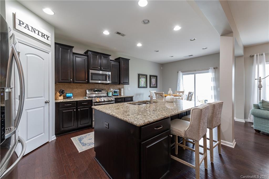 79362 Ridgehaven Road Lancaster, SC 29720 - Photo 7 of 37 a kitchen with stainless steel appliances granite countertop a table chairs sink refrigerator and cabinets