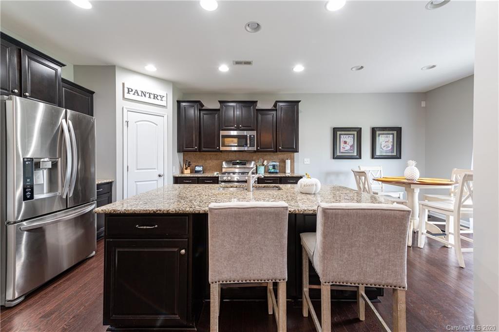 79362 Ridgehaven Road Lancaster, SC 29720 - Photo 8 of 37 a kitchen with stainless steel appliances granite countertop a dining table chairs refrigerator and microwave