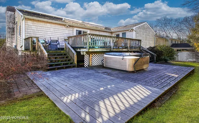 a view of a roof deck with couches chairs and wooden fence