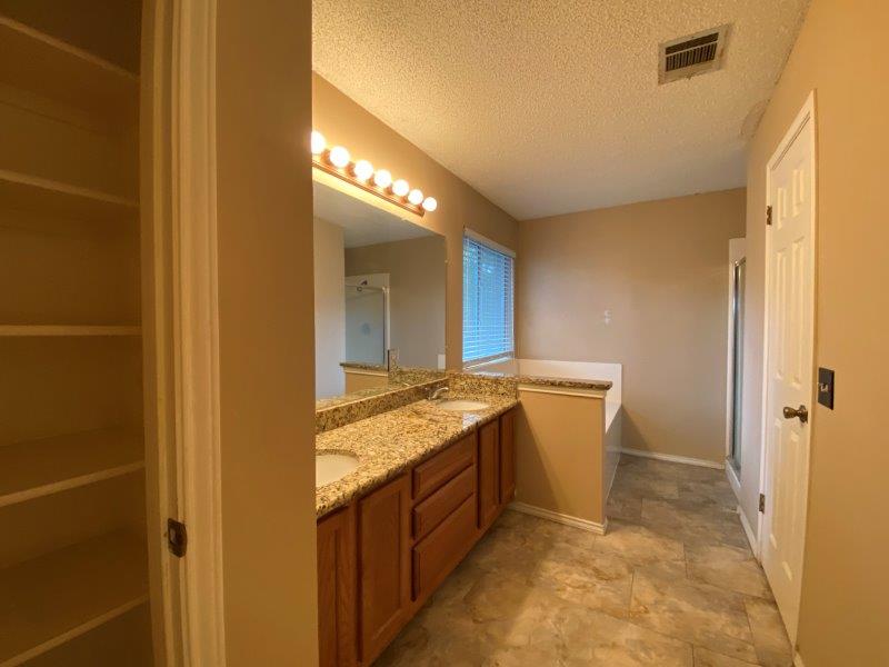 1903 Balsam Way Round Rock, TX 78665 - Photo 9 of 21 Double vanity with granite counters and tile flooring highlight this well-appointed Primary bathroom.