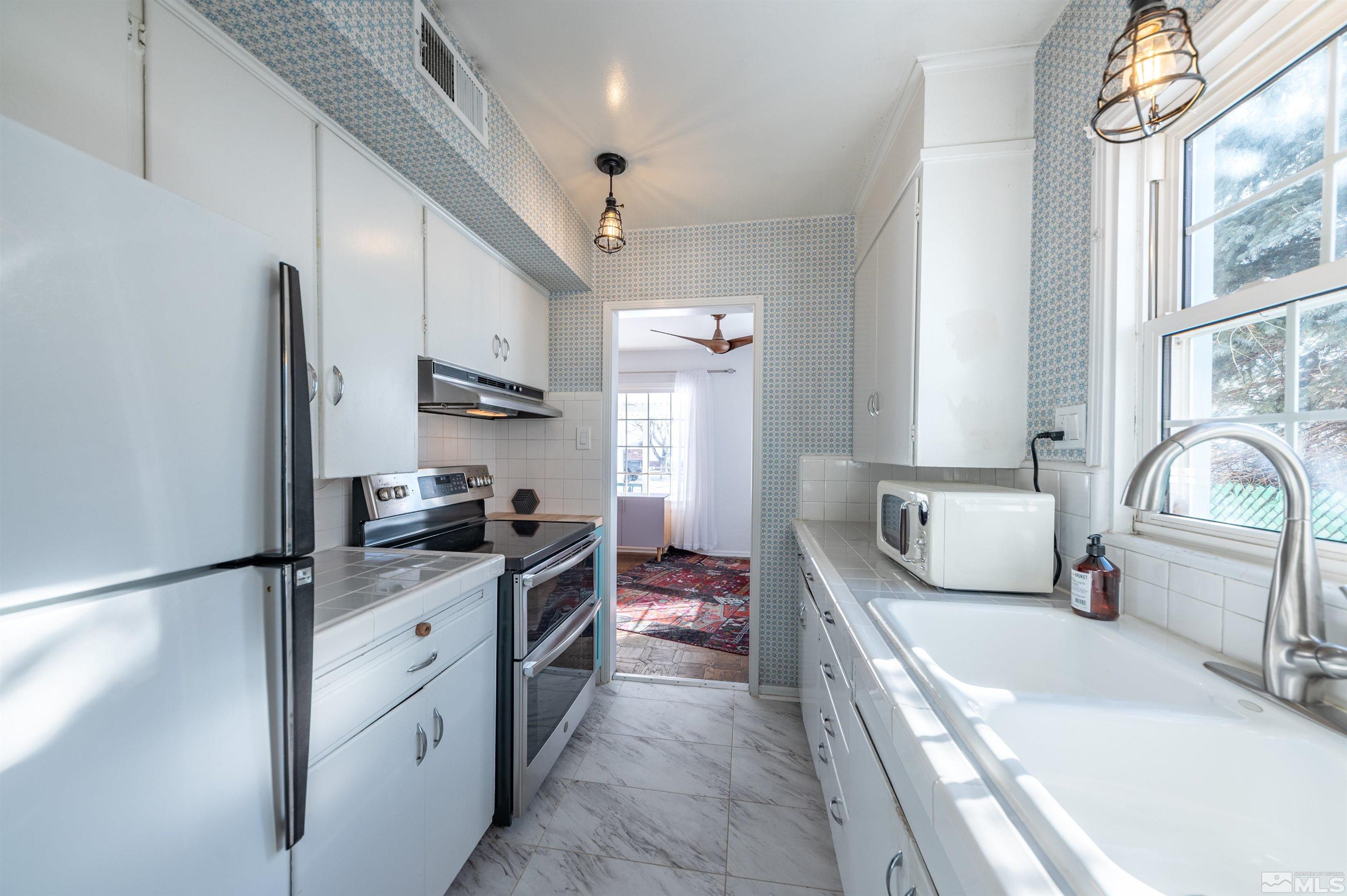997 Meadow Street Reno, NV 89509 - Photo 13 of 33 a kitchen with stainless steel appliances a sink stove and refrigerator