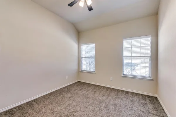 an empty room with window and hardwood floor