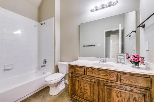 a bathroom with a granite countertop toilet sink and mirror