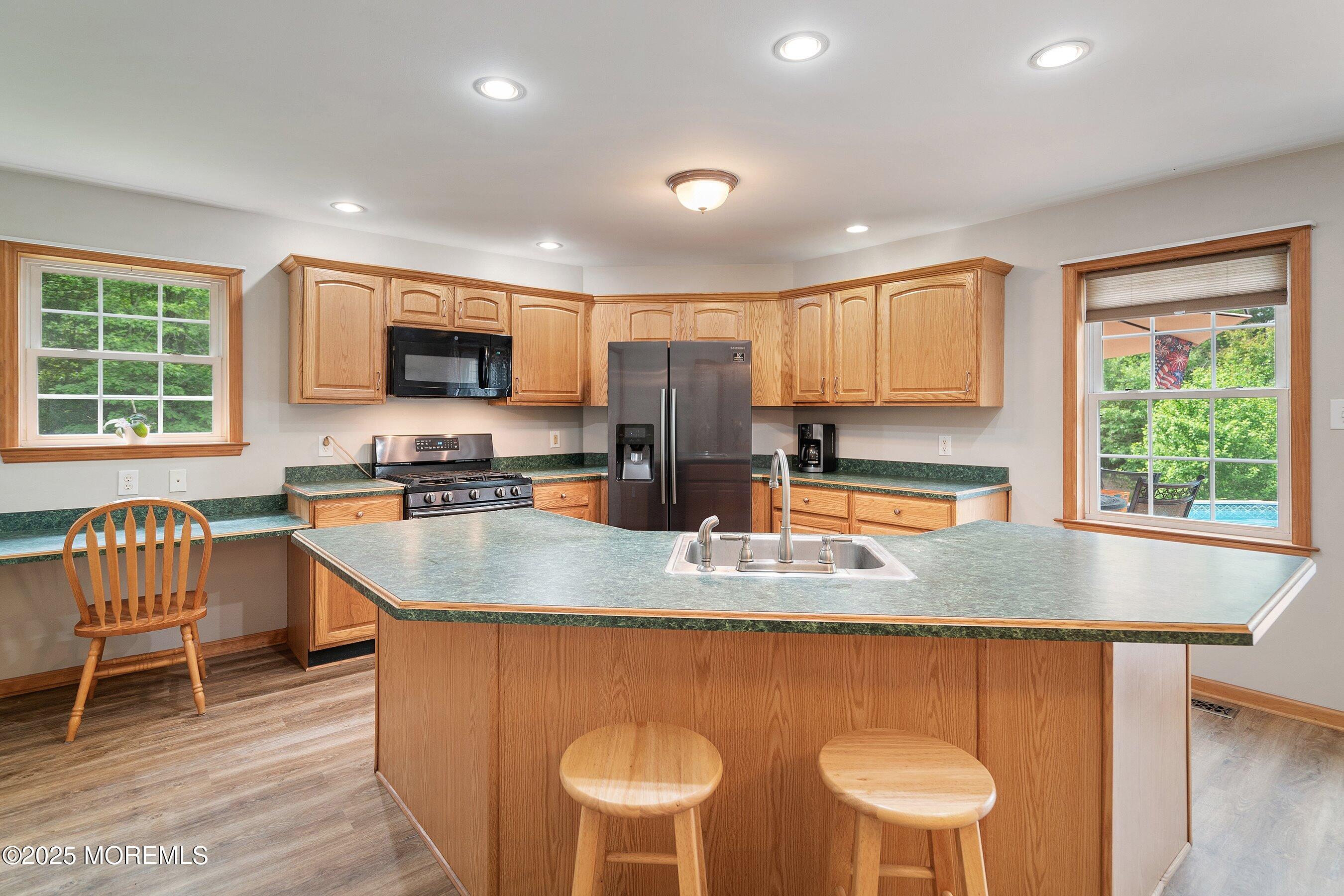 10 Hillside Avenue Tuckerton, NJ 08087 - Photo 14 of 46 a kitchen with stainless steel appliances granite countertop a stove a sink a microwave a dining table and chairs