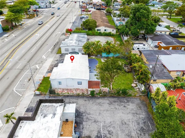 an aerial view of a house with a yard and lake view