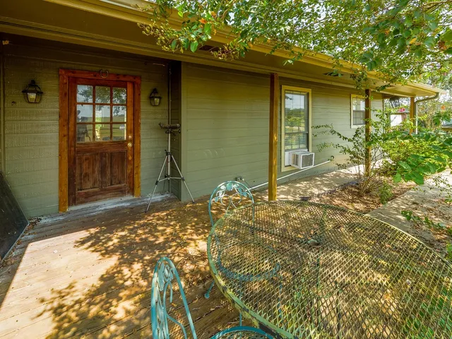 a view of a swimming pool with a lounge chair and trees in the background