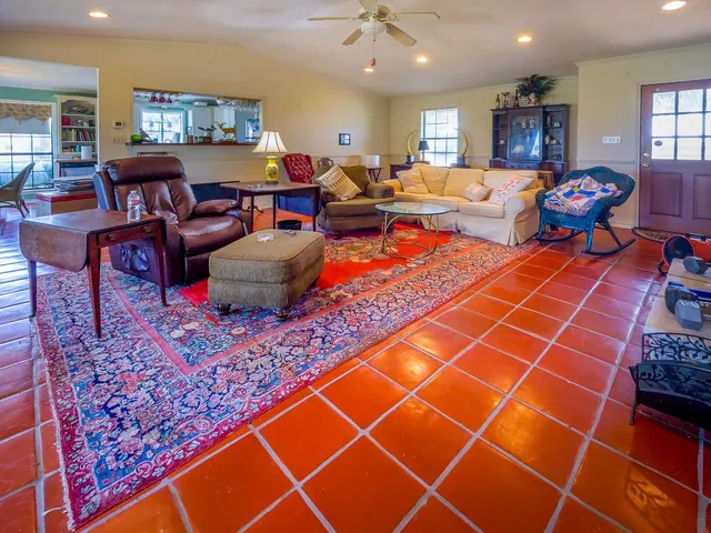 a living room with furniture a rug and a bookshelf