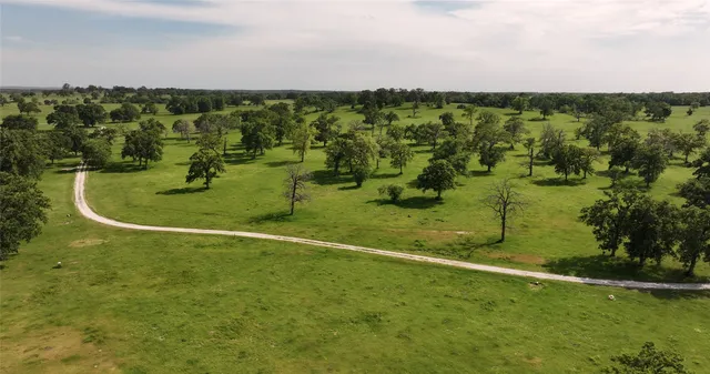 an aerial view of a houses with a lush green hillside