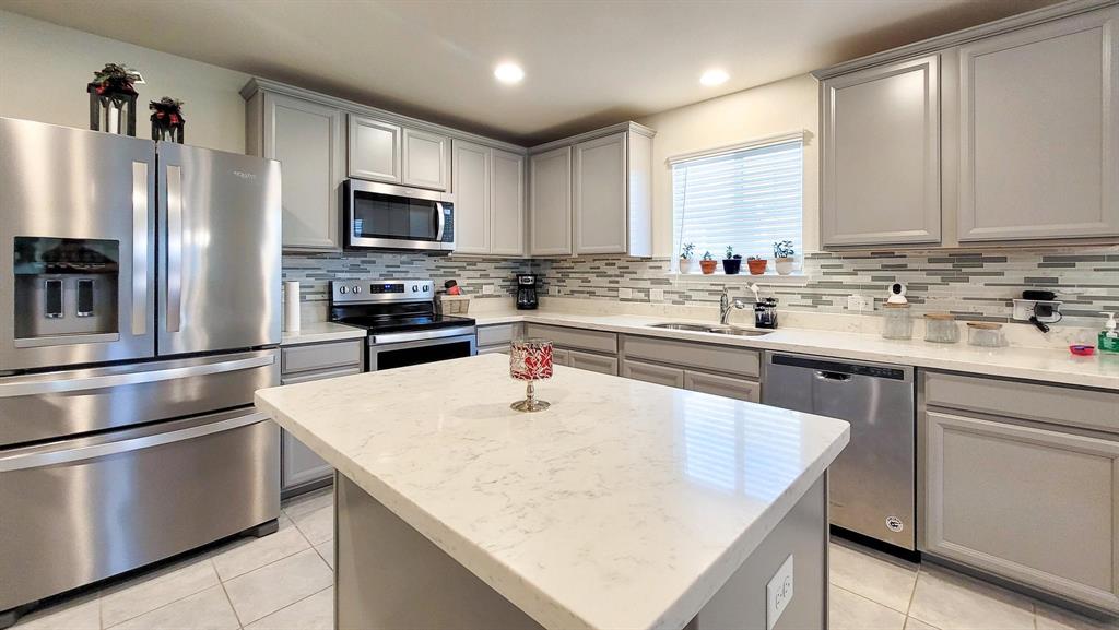 a kitchen with appliances a sink and cabinets