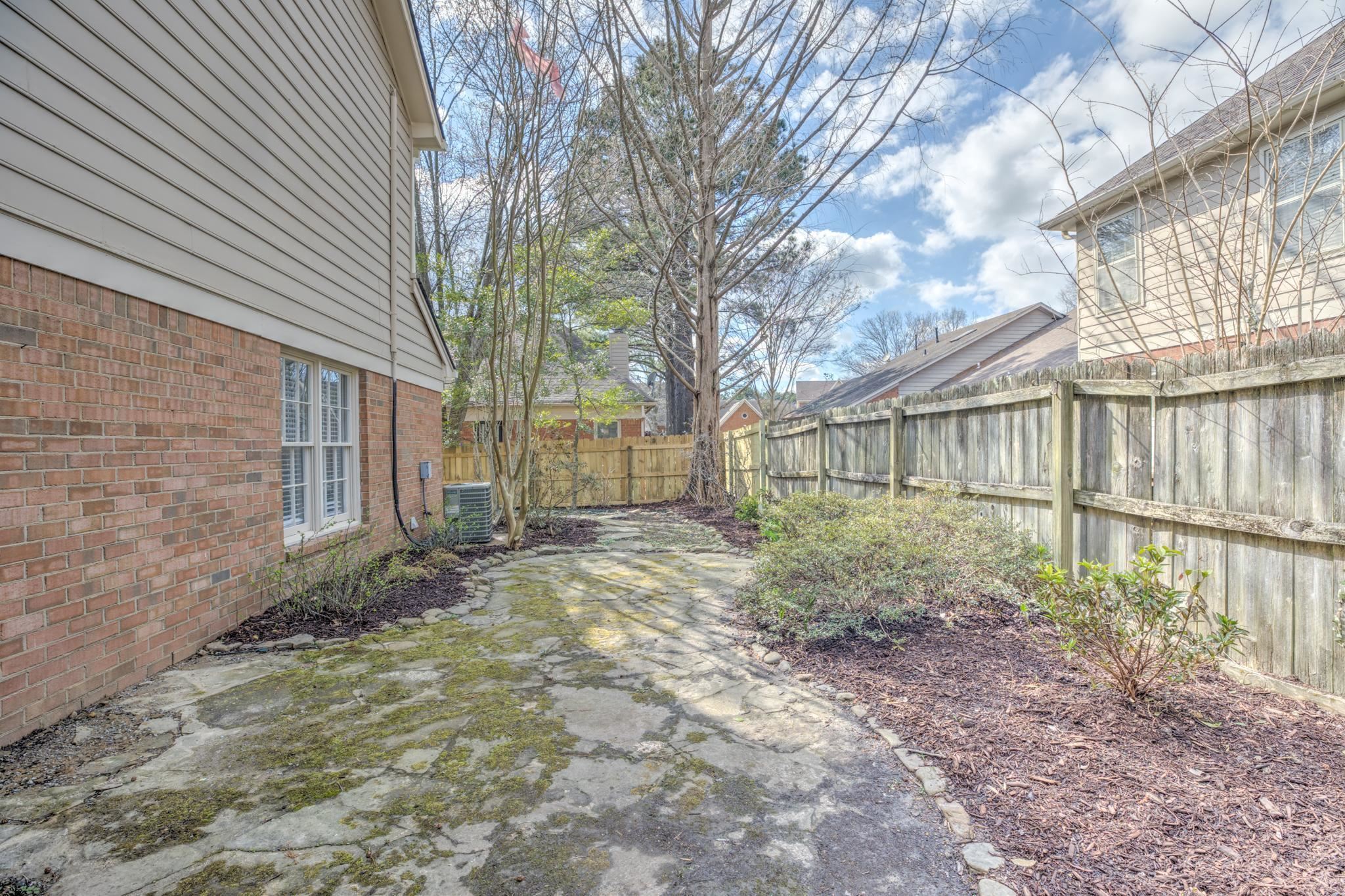 3997 Sawgrass Drive Memphis, TN 38125 - Photo 24 of 24 a view of a backyard that has large trees and a wooden fence