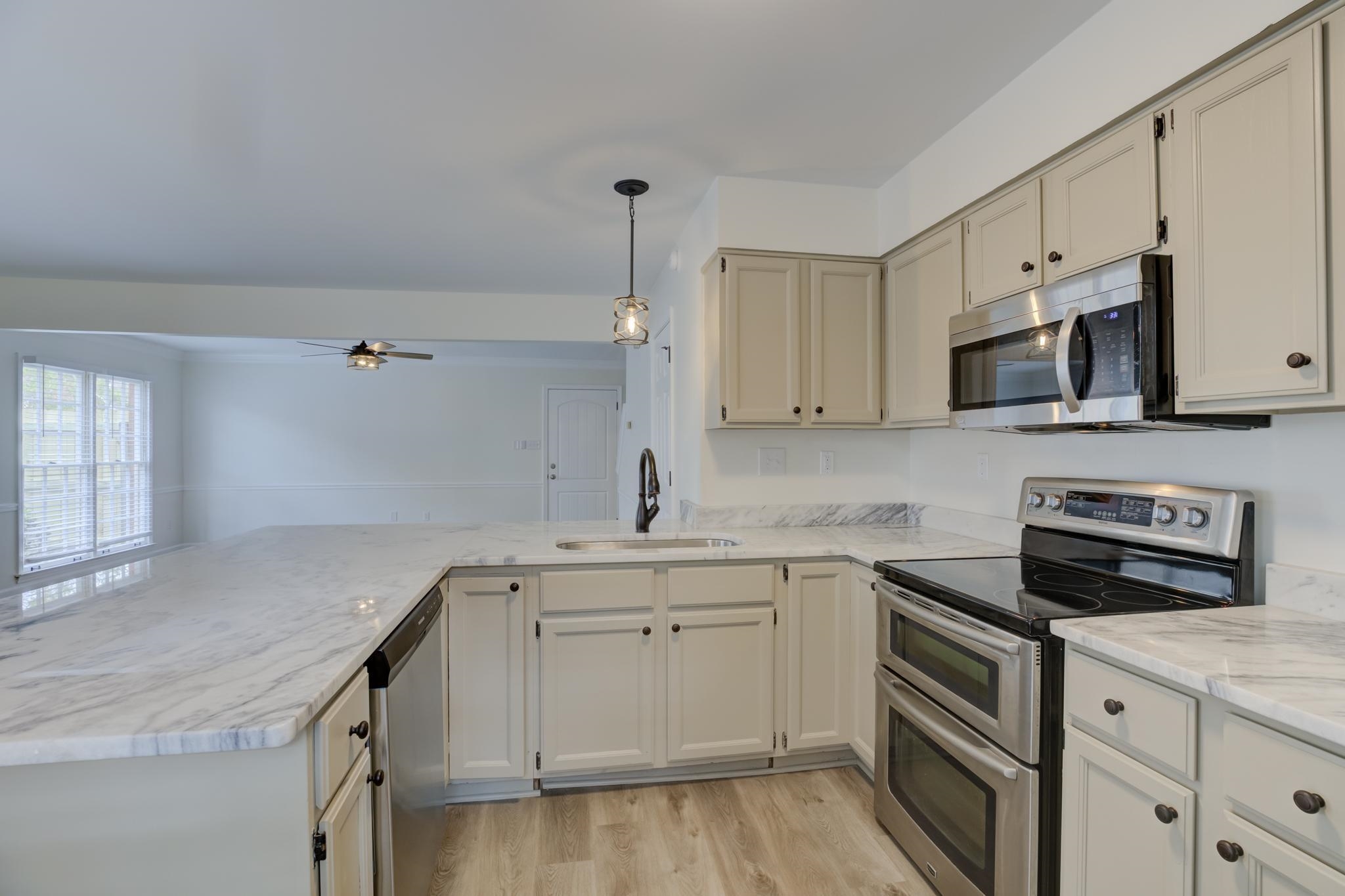 3997 Sawgrass Drive Memphis, TN 38125 - Photo 9 of 24 a kitchen with a sink stove and cabinets