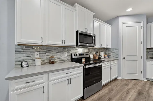 a kitchen with appliances a sink and cabinets
