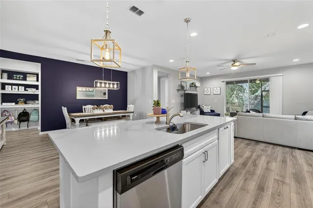 a kitchen with stainless steel appliances a sink a stove top oven a counter space and cabinets