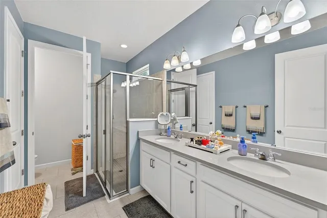 a spacious bathroom with a double vanity sink mirror and shower