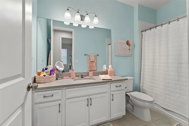 a bathroom with a double vanity sink mirror and toilet