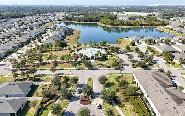 an aerial view of ocean and residential houses with outdoor space