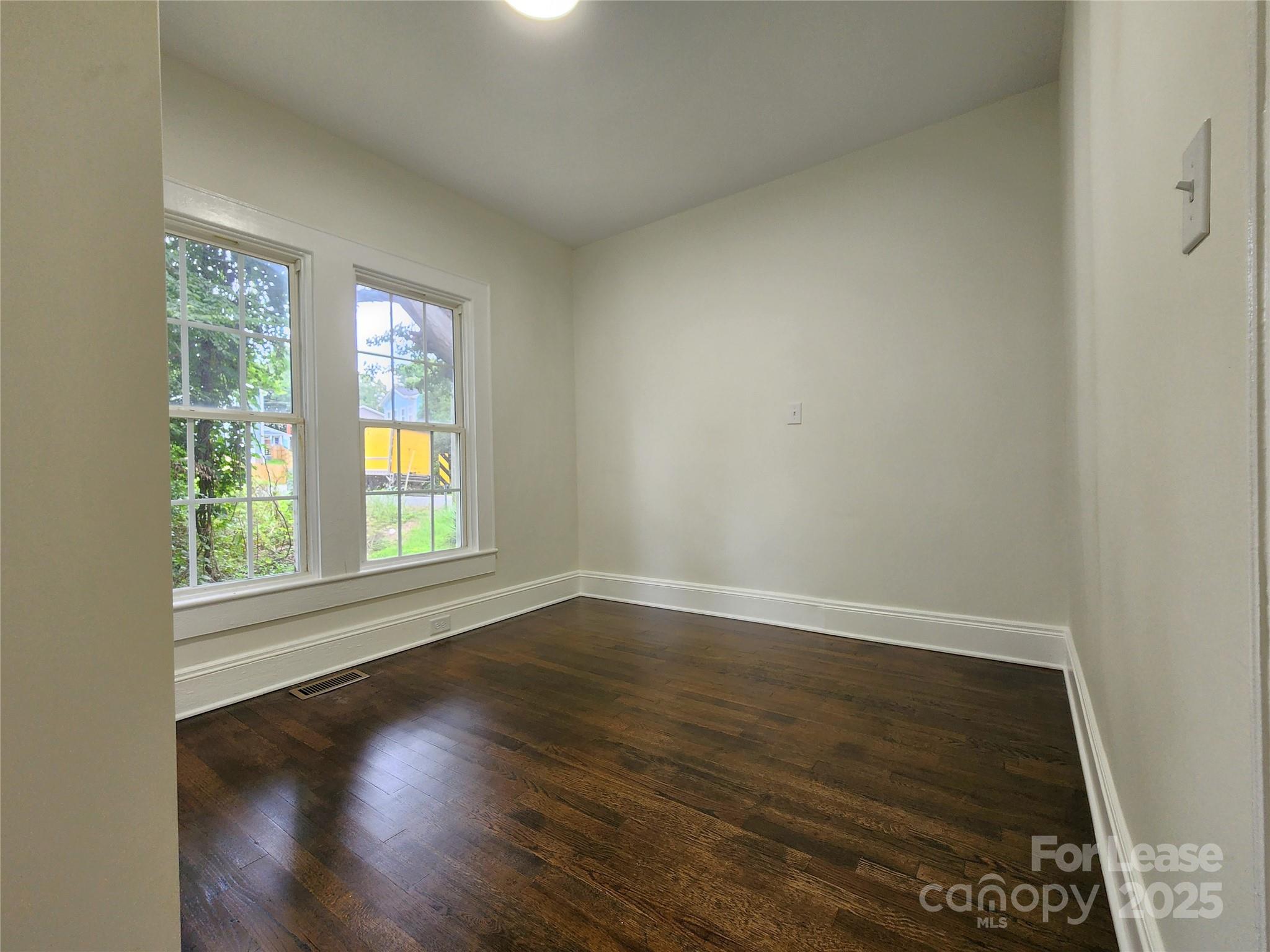 179 Duval Street Northwest Concord, NC 28025 - Photo 12 of 18 an empty room with wooden floor and windows