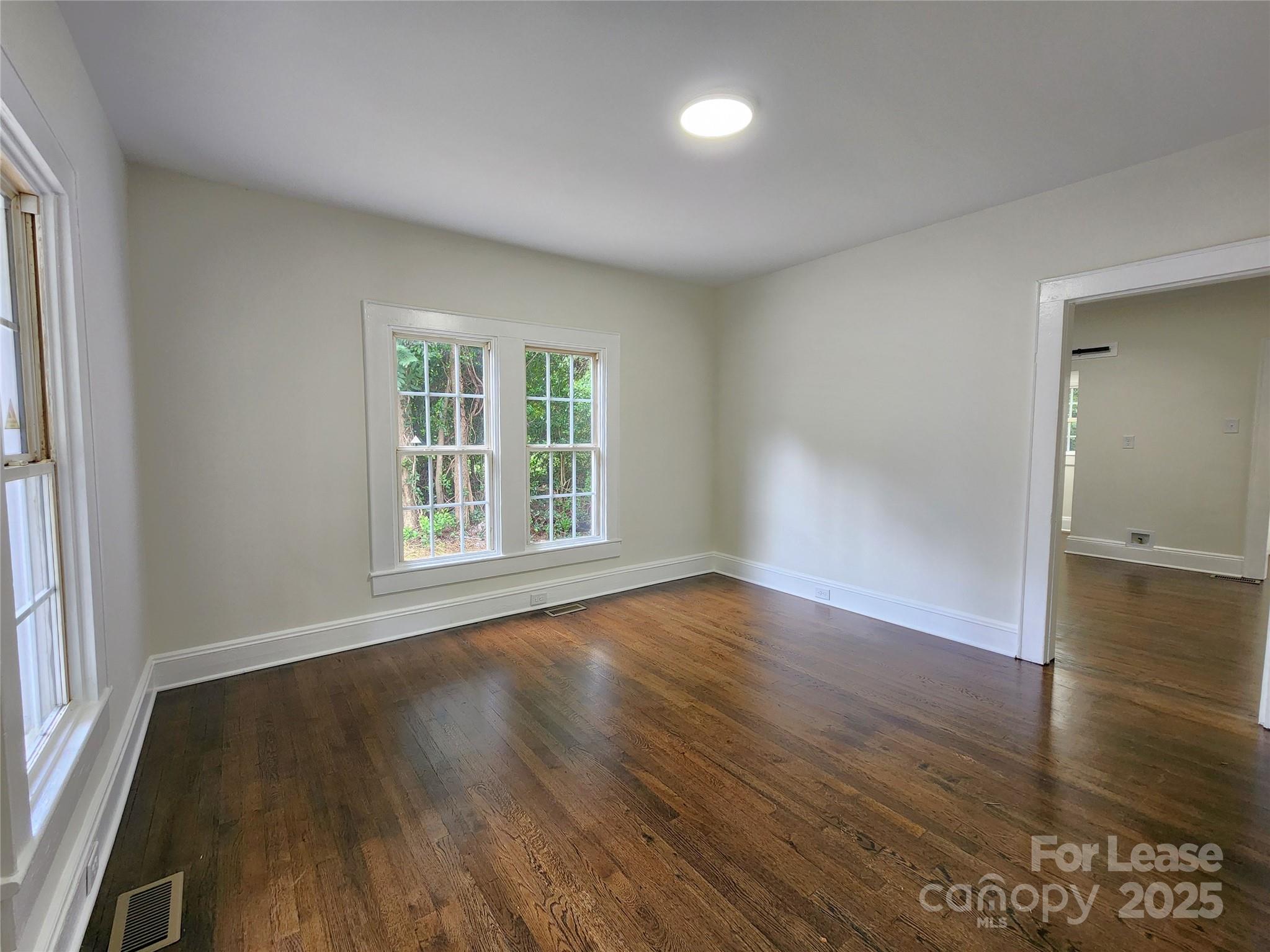 179 Duval Street Northwest Concord, NC 28025 - Photo 3 of 18 an empty room with wooden floor and windows