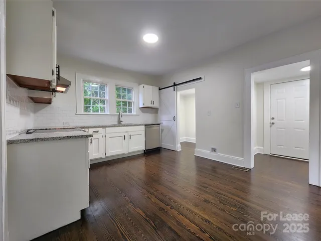 a kitchen with a sink cabinets stainless steel appliances and a window