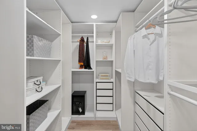a view of walk in closet with clothes and shoes