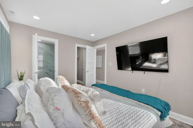 a bedroom with a large bed and a flat screen tv