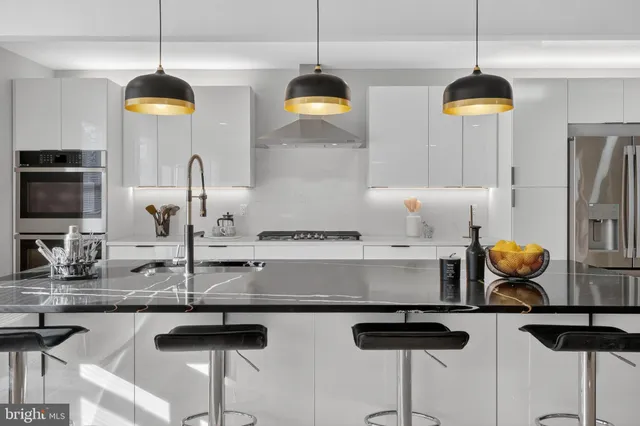 a kitchen with stainless steel appliances granite countertop a stove a sink and a chandelier