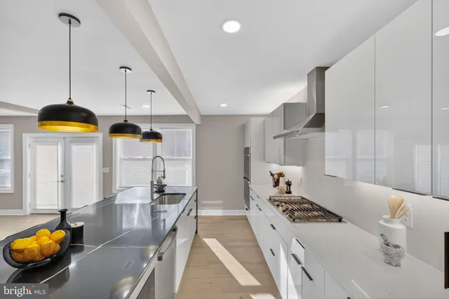 a kitchen with stainless steel appliances kitchen island granite countertop a stove a sink and a white cabinets