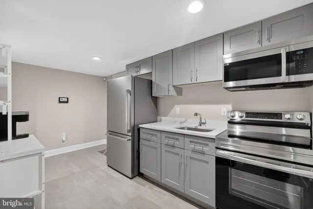 a kitchen with stainless steel appliances a sink dishwasher a refrigerator and microwave