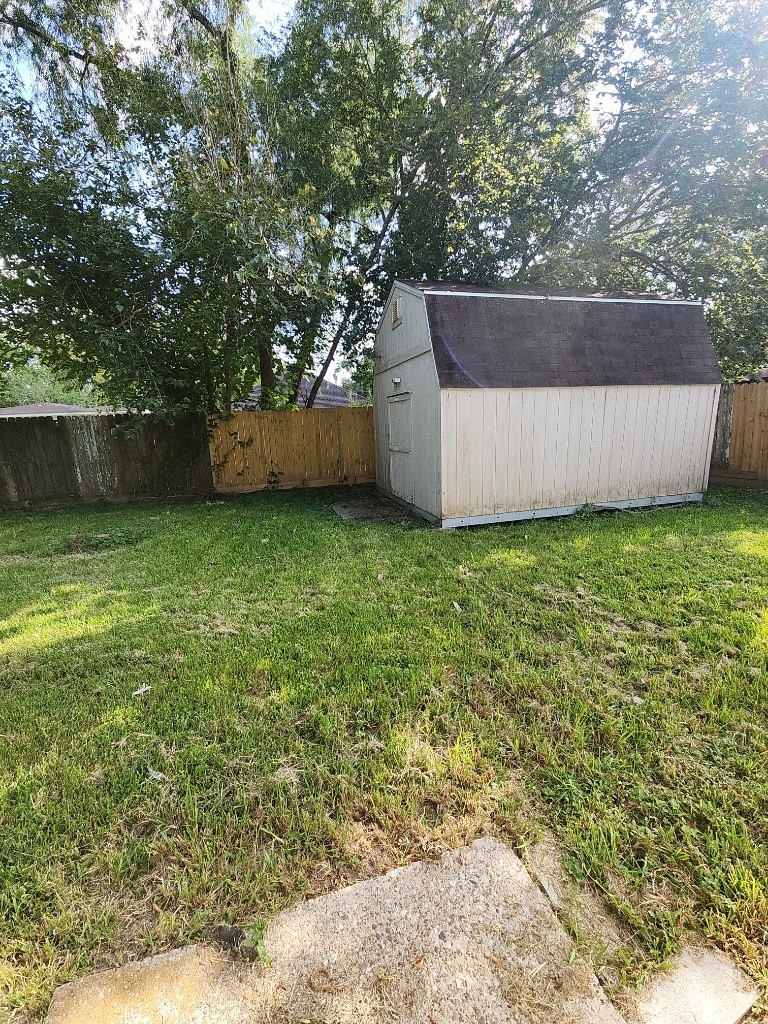 12109 22nd Street Santa Fe, TX 77510 - Photo 14 of 14 a view of a backyard with a small cabin and a chair