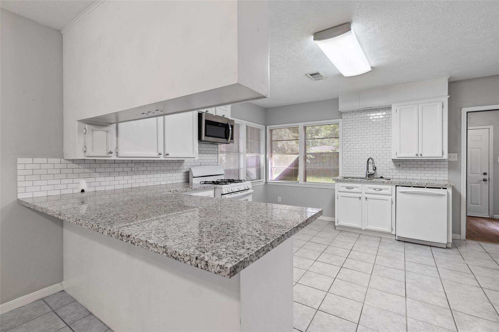 12109 22nd Street Santa Fe, TX 77510 - Photo 2 of 14 a kitchen with stainless steel appliances granite countertop a sink stove and cabinets