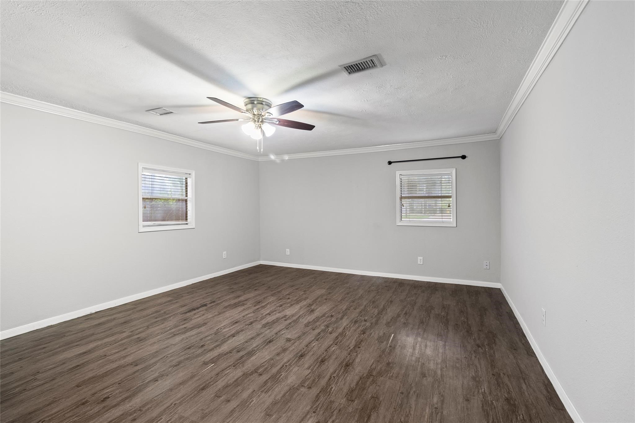 12109 22nd Street Santa Fe, TX 77510 - Photo 7 of 14 a view of an empty room with a window and wooden floor
