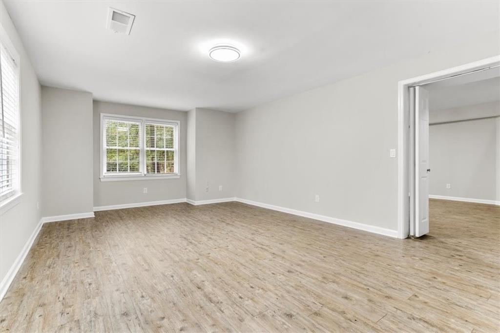 3425 Kingsland Circle Berkeley Lake, GA 30096 - Photo 38 of 45 an empty room with wooden floor and windows