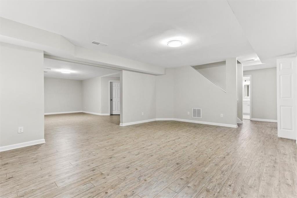 3425 Kingsland Circle Berkeley Lake, GA 30096 - Photo 40 of 45 an empty room with wooden floor and windows