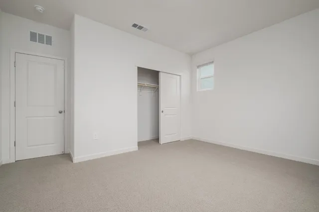 a view of a white house with a yard and large windows