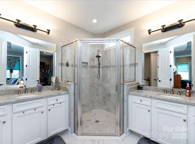 a bathroom with a shower sink vanity granite and mirror