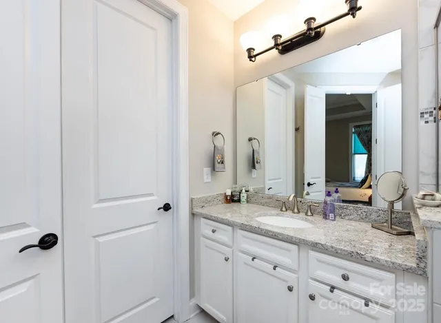 a bathroom with a granite countertop sink and a mirror