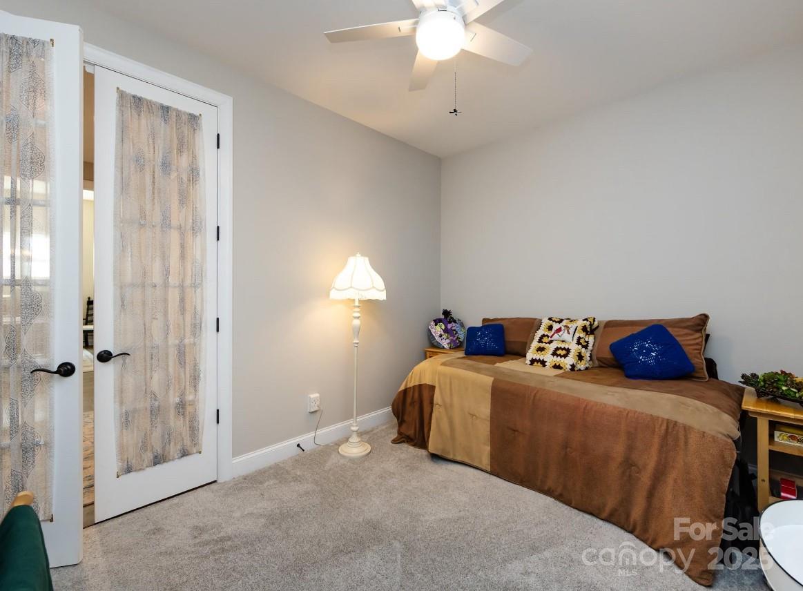 7337 Overjoyed Crossing Charlotte, NC 28215 - Photo 24 of 28 a living room with a bed and a chandelier