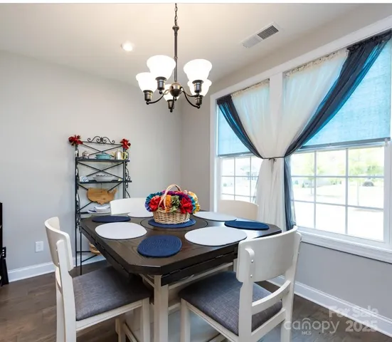 a view of a dining room with furniture a chandelier and wooden floor