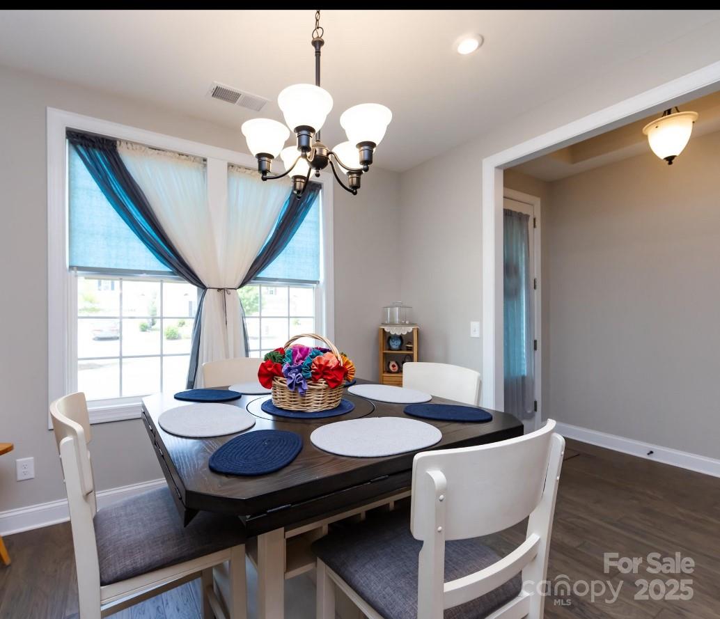 7337 Overjoyed Crossing Charlotte, NC 28215 - Photo 6 of 28 a view of a dining room with furniture wooden floor and chandelier