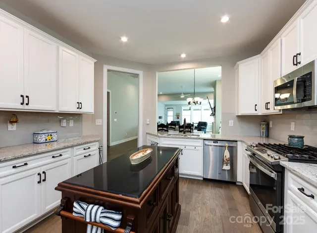 a kitchen with stainless steel appliances a stove a sink a stove and cabinets