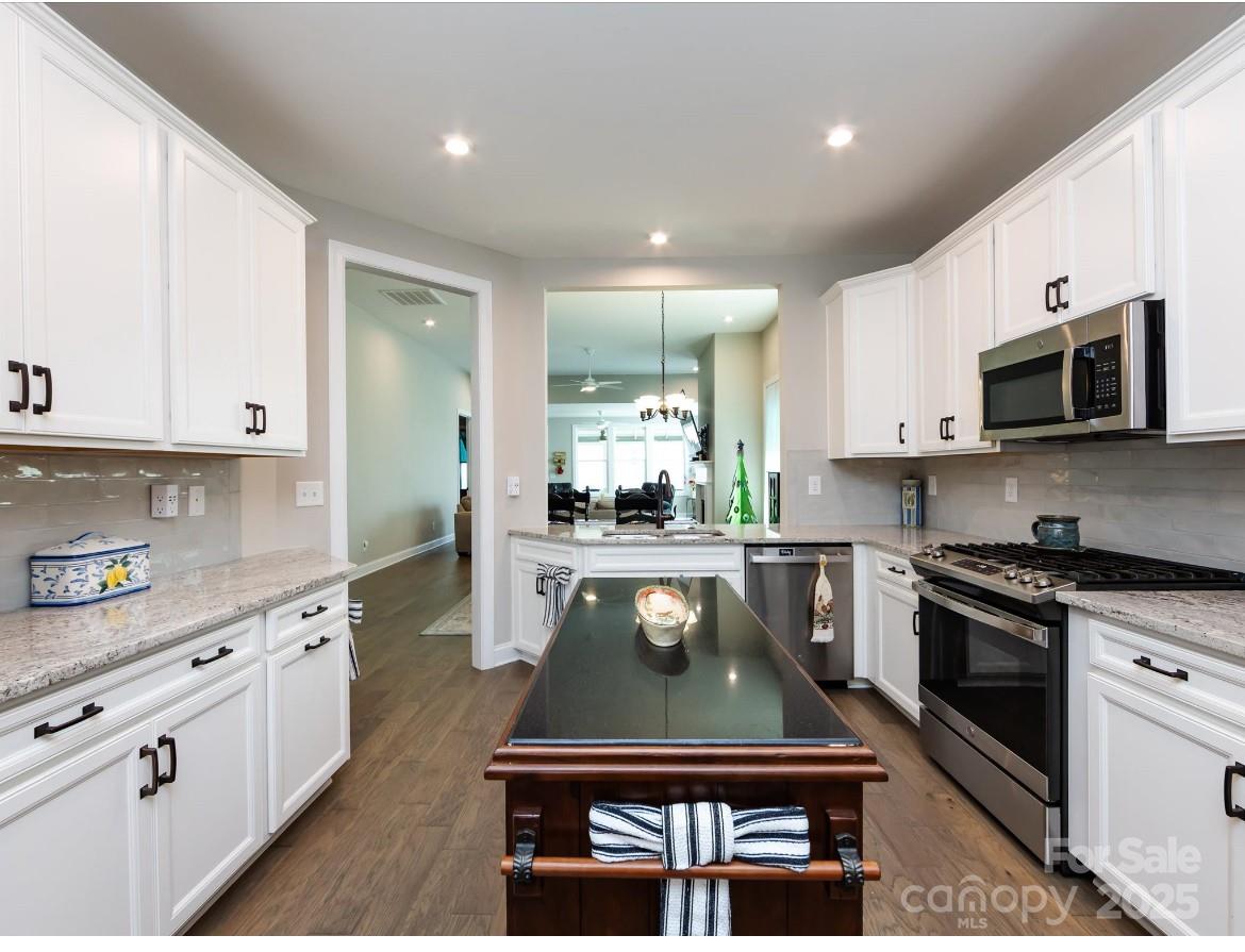 7337 Overjoyed Crossing Charlotte, NC 28215 - Photo 9 of 28 a kitchen with stainless steel appliances granite countertop a stove a sink and a microwave