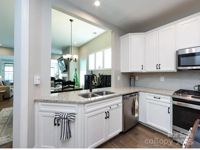 a kitchen with a sink stove and white cabinets